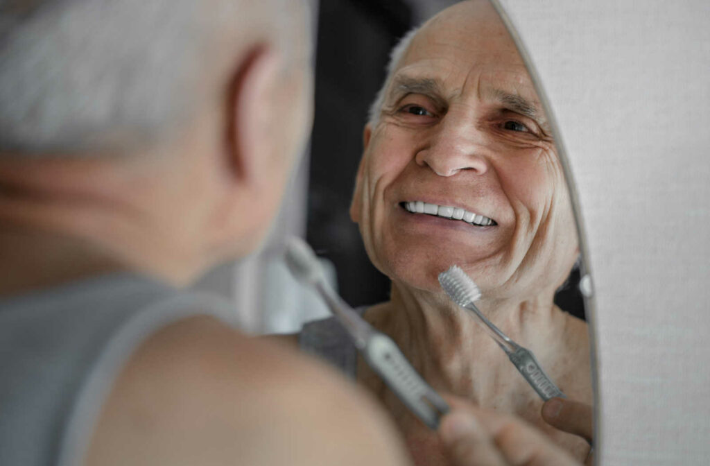 Old person checking his teeth before brushing his teeth.