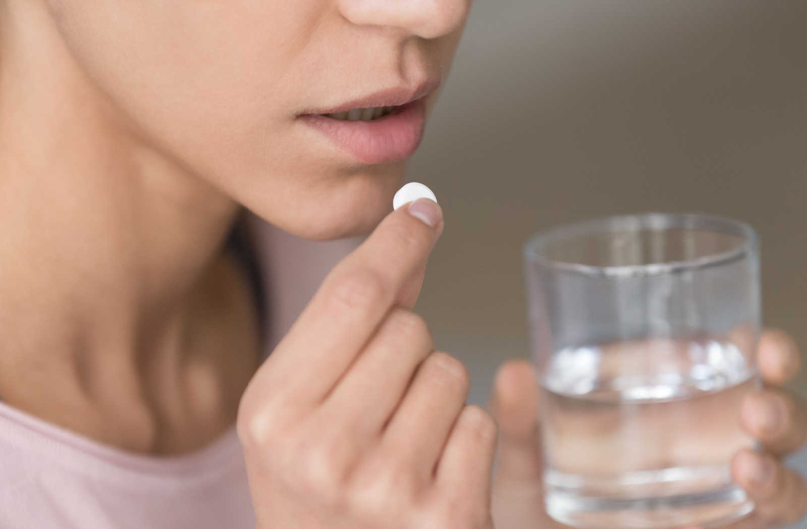 A woman taking an antibiotic pill.